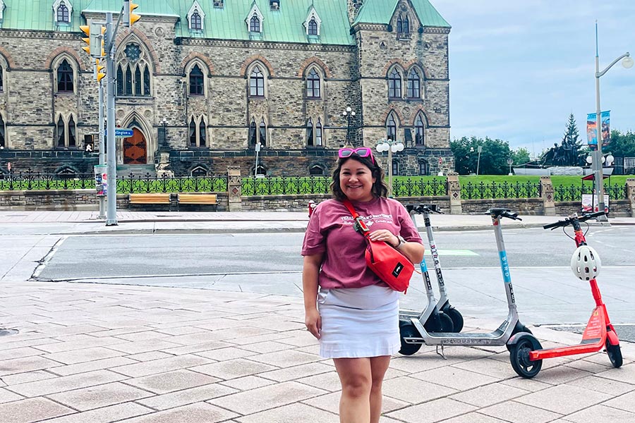 Vivian Orellana stands in front of a historical building 