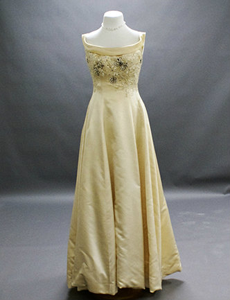 A white silk satin gown with appliqu&eacute;d beading of crystals, pearls and rhinestones.