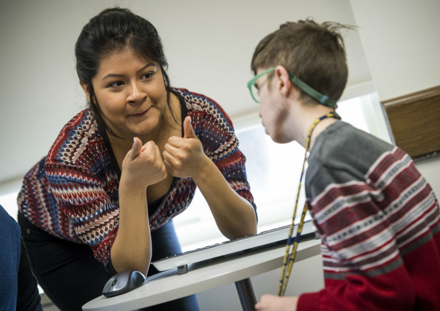 woman gives thumbs up to pre-teen boy in red sweater