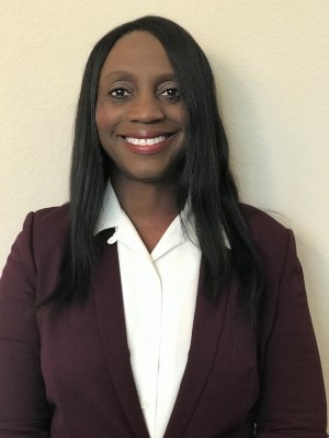 A portrait of Katherine Green smiling and wearing a maroon blazer.
