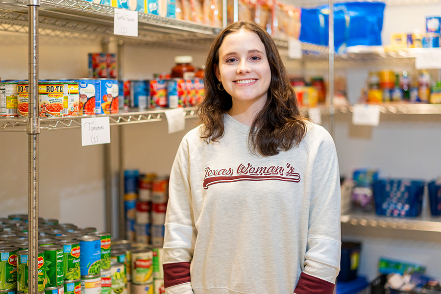Alexandra Mack stands in pantry with food on shelves behind her