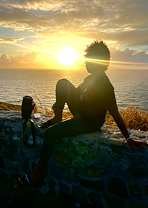 a sunset on the ocean with a pier in the foreground