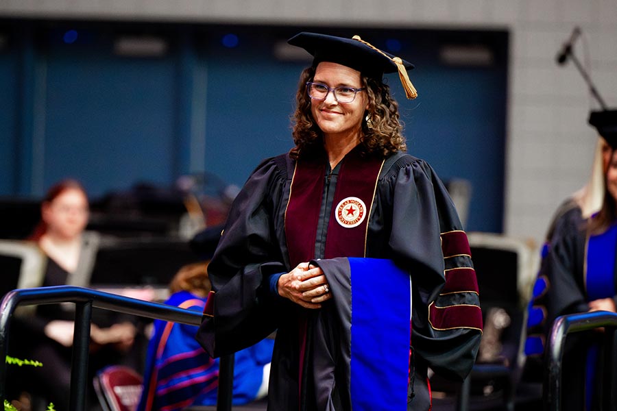 a PhD student in graduation robes