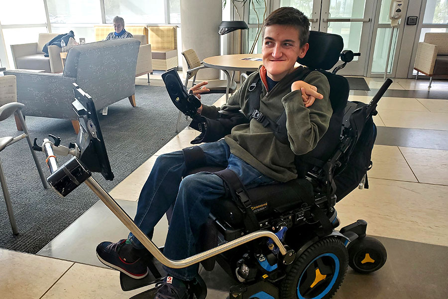 Stroke Center volunteer uses AAC device attached to wheelchair to communicate
