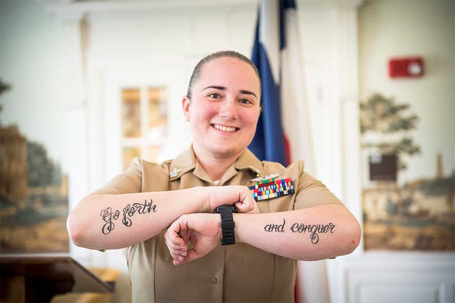 A TWU student and veteran smiles on the Denton campus in military uniform.	